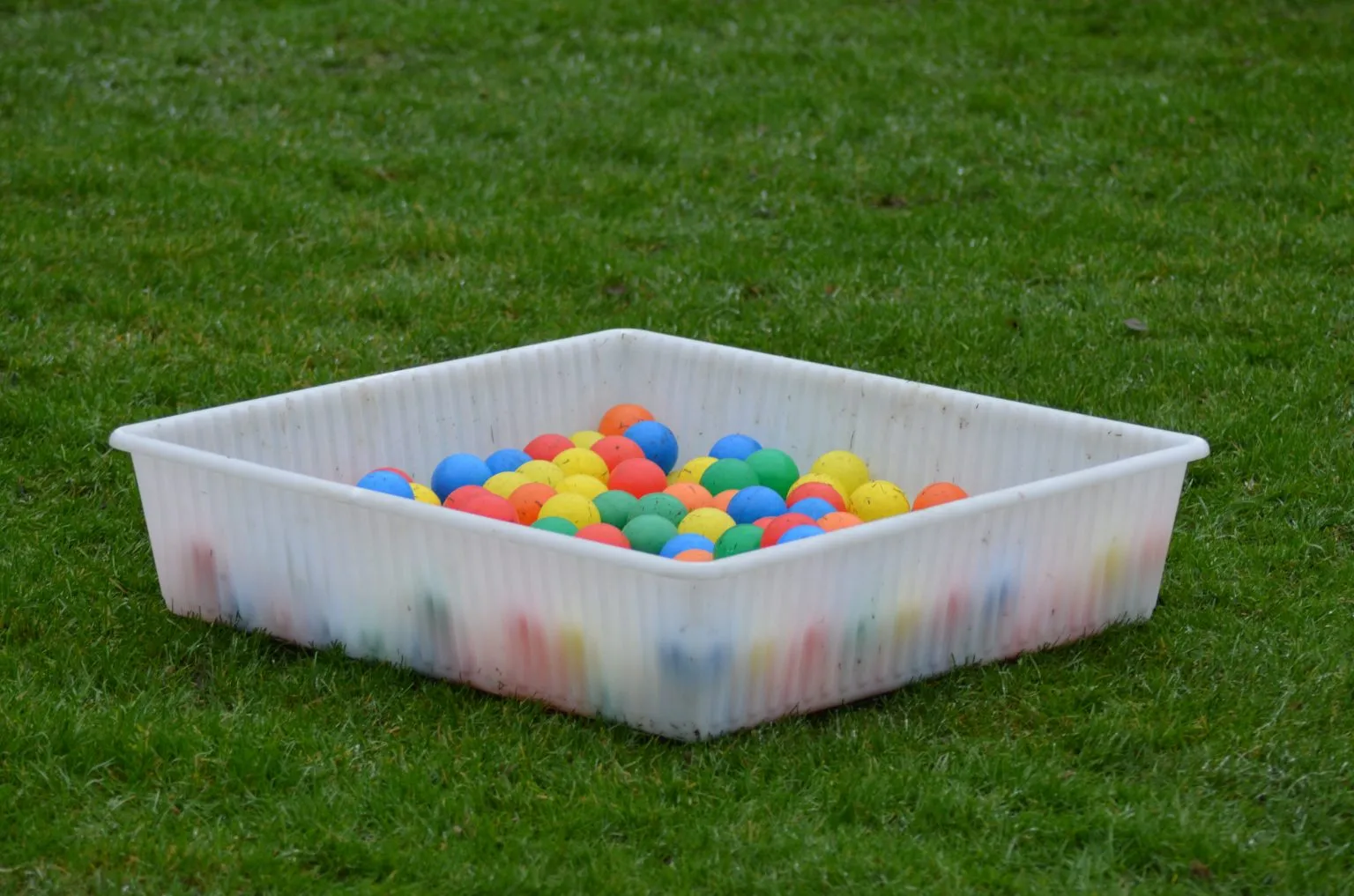 De ballenzoekbak op het trainingsveld, gevuld met gekleurde ballen